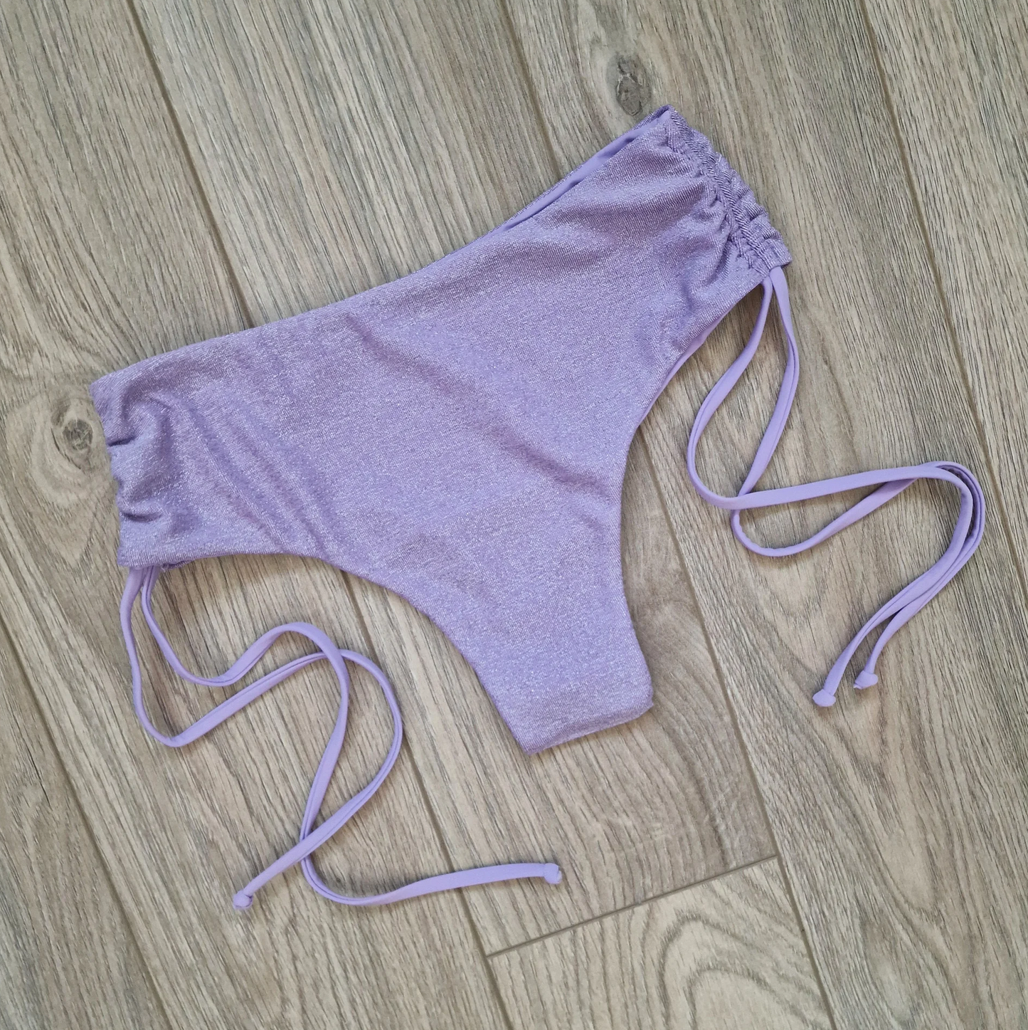 Front view of Luscious Lilac Glitter Cheeky Shorts for pole dance. Showcases the sparkling lilac glitter overlay and adjustable sides for a perfect fit